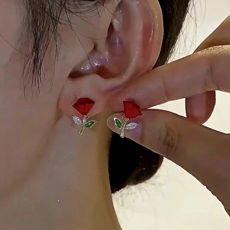 Model showcasing the dangle and style of the 14K Gold-Plated Elegant Red Rose Stud Earrings