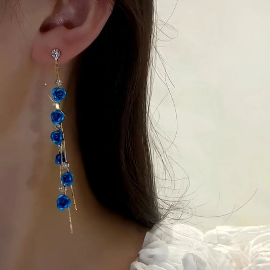 Model showcasing the dangle and style of the 14K Gold-Plated Elegant Rhinestone Blue Rose Tassel Earrings