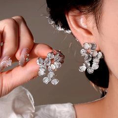 Model showcasing the dangle and style of the 14K Gold-Plated Elegant Round Pattern Leaf Tassel Earrings