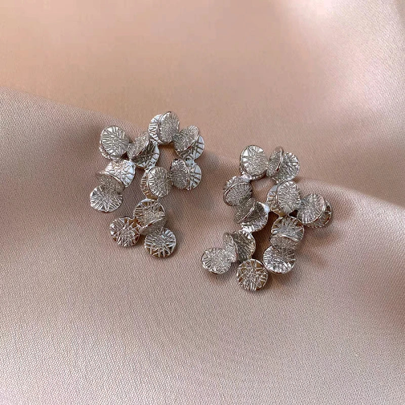 Angled view of the 14K Gold-Plated Elegant Round Pattern Leaf Tassel Earrings