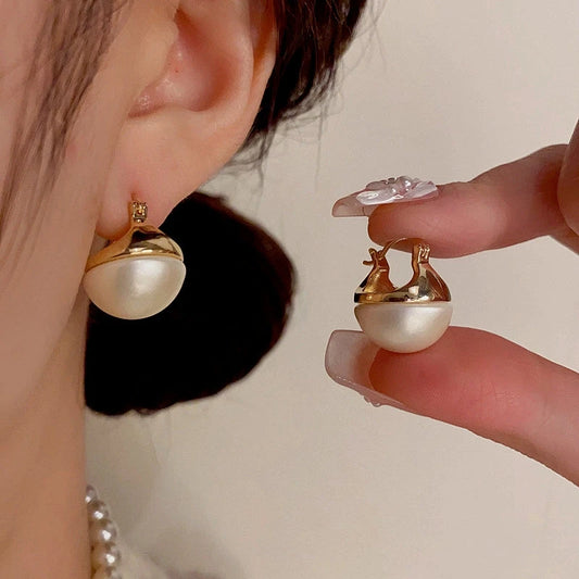 Model showcasing the dangle and style of the 14K Gold-Plated Elegant Round Pearl Earrings