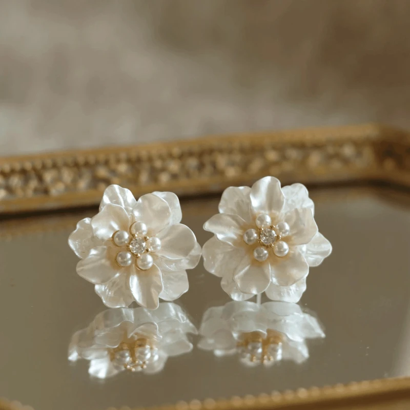 Angled view of the 14K Gold-Plated Elegant Shall Flower Pearl Stud Earrings