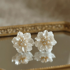 Angled view of the 14K Gold-Plated Elegant Shall Flower Pearl Stud Earrings