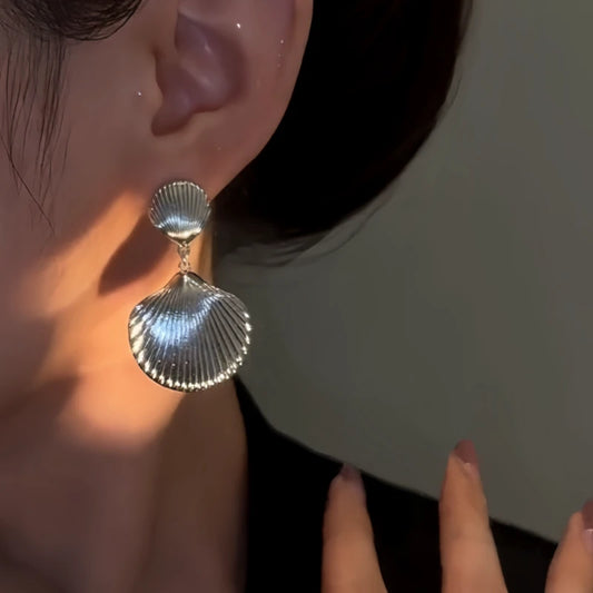 Model showcasing the dangle and style of the 14K Gold-Plated Elegant Shell Tassel Earrings