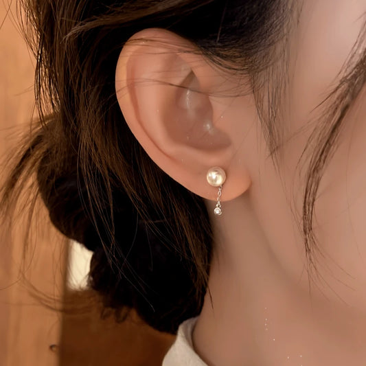 Model showcasing the dangle and style of the 14K Gold-Plated Elegant Short Chain Pearl Earrings