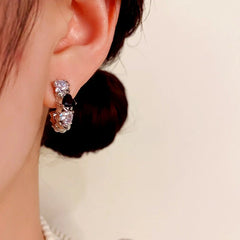 Model showcasing the dangle and style of the 14K Gold-Plated Elegant Simple Cold Style Zircon Heart Earrings