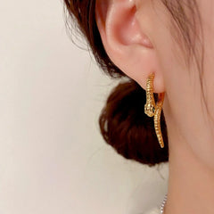 Model showcasing the dangle and style of the 14K Gold-Plated Elegant Snake-Shaped Earrings