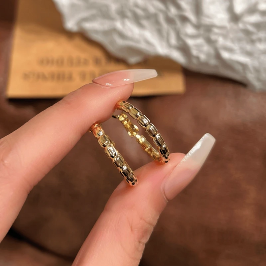 Model showcasing the dangle and style of the 14K Gold-Plated Elegant Snake Bone Hoop Earrings