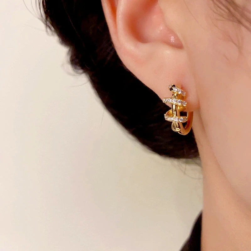 Model showcasing the dangle and style of the 14K Gold-Plated Elegant Snake Design Hoop Earrings