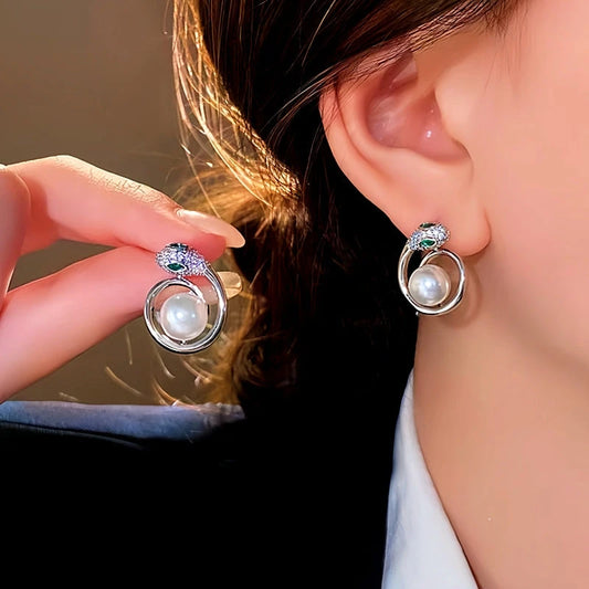 Model showcasing the dangle and style of the 14K Gold-Plated Elegant Snake Pearl Earrings