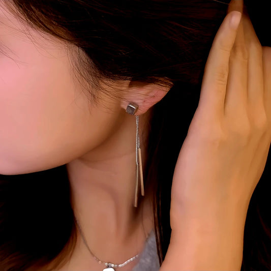 Model showcasing the dangle and style of the 14K Gold-Plated Elegant Square Tassel Earrings