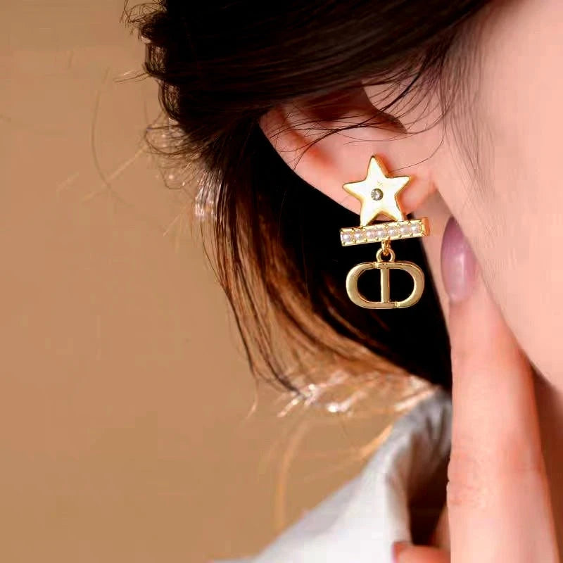 Model showcasing the dangle and style of the 14K Gold-Plated Elegant Star Pearl Earrings