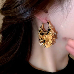 Model showcasing the dangle and style of the 14K Gold-Plated Elegant Star Tassel Earrings