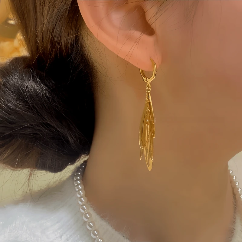 Model showcasing the dangle and style of the 14K Gold-Plated Elegant Tassel Earrings