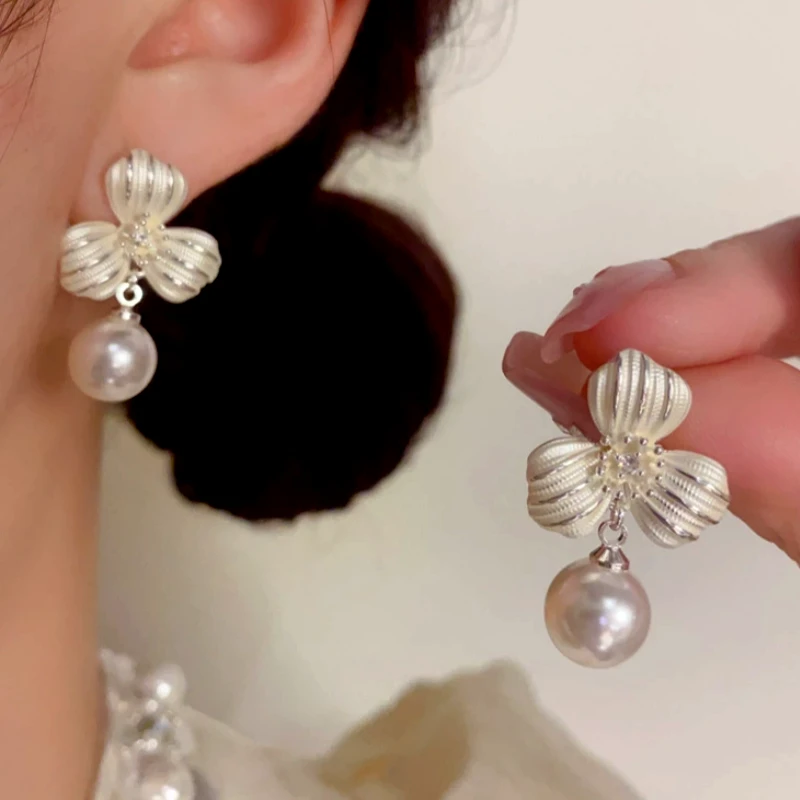Angled view of the 14K Gold-Plated Elegant Thick Silver Clover Pearl Earrings