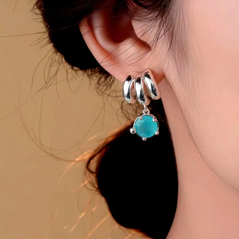 Model showcasing the dangle and style of the 14K Gold-Plated Elegant Three-Layer Green Zircon Water Drop Earrings