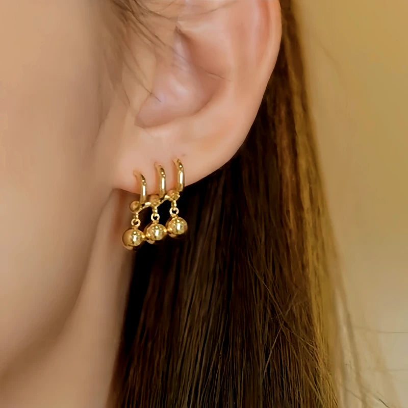 Model showcasing the dangle and style of the 14K Gold-Plated Elegant Three-Layer Water Drop Earrings