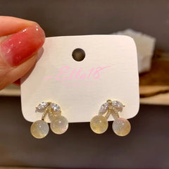 Model showcasing the dangle and style of the 14K Gold-Plated Elegant Transparent Cherry Earrings