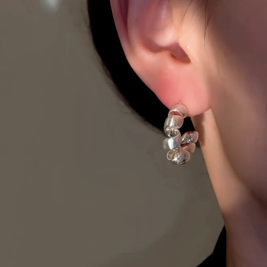 Model showcasing the dangle and style of the 14K Gold-Plated Elegant Twisted C-Shaped Earrings