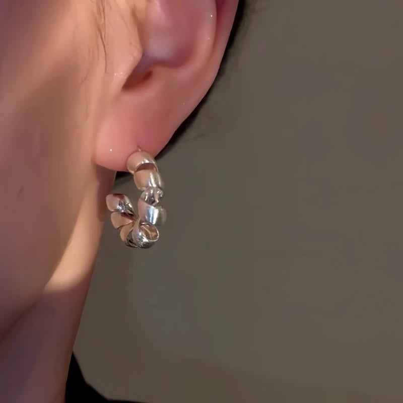 Close-up detail of the sparkling zircons and plating on the Twisted C-Shaped Hoops