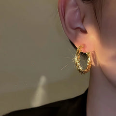 Close-up detail of the sparkling zircons and plating on the Twisted Gold Hoops