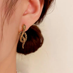 Model showcasing the dangle and style of the 14K Gold-Plated Elegant Vintage Black Metal Snake Earrings