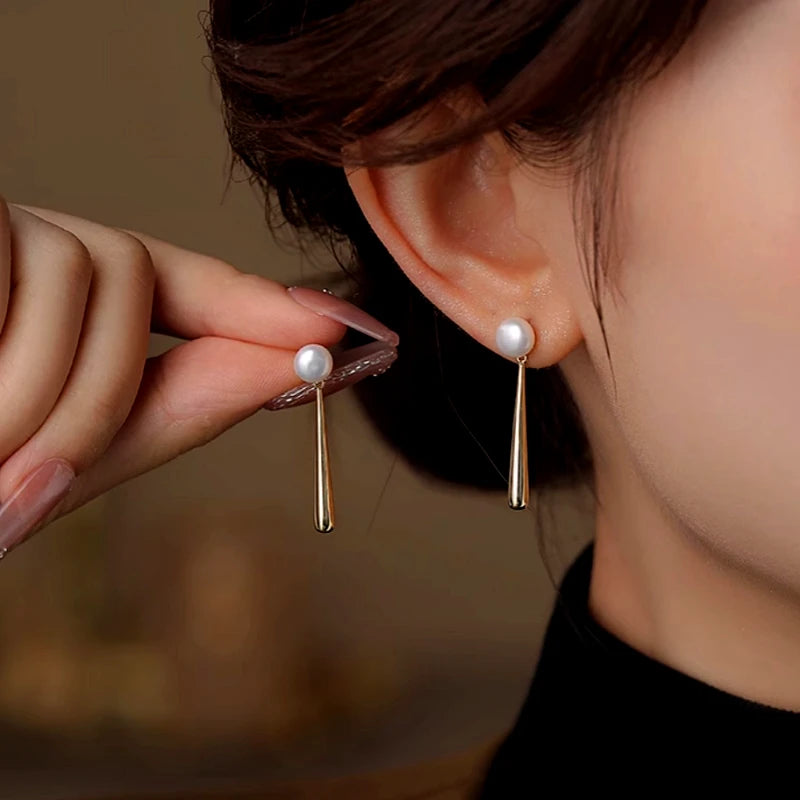 Model showcasing the dangle and style of the 14K Gold-Plated Elegant Water Drop Pearl Earrings