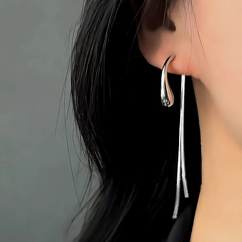 Model showcasing the dangle and style of the 14K Gold-Plated Elegant Water Drop Tassel Earrings