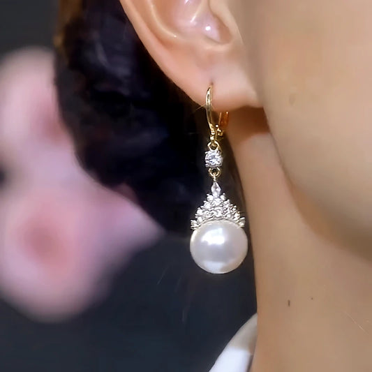 Model showcasing the dangle and style of the 14K Gold-Plated Elegant White Pearl Zircon Crown Earrings