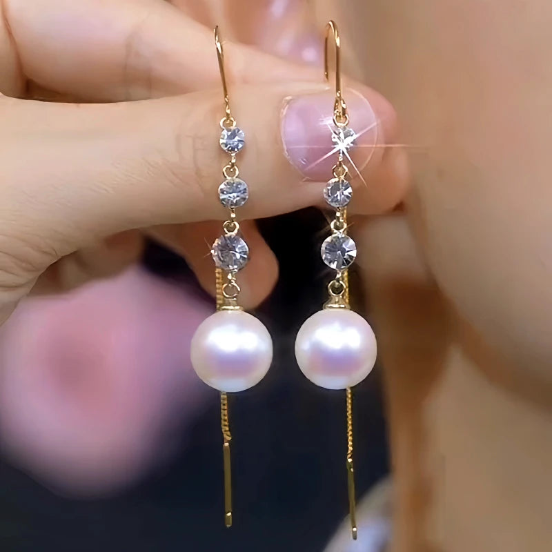 Model showcasing the dangle and style of the 14K Gold-Plated Elegant White Pearl Zircon Tassel Threader Earrings