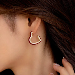 Model showcasing the dangle and style of the 14K Gold-Plated Elegant Wine Red Glaze Heart Earrings
