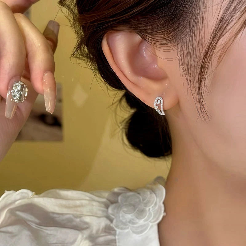 Model showcasing the dangle and style of the 14K Gold-Plated Elegant Zircon Angel Wing Hoop Earrings