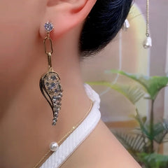 Model showcasing the dangle and style of the 14K Gold-Plated Elegant Zircon Angel Wing Tassel Earrings