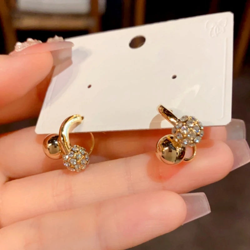 Angled view of the 14K Gold-Plated Elegant Zircon Ball Cross Earrings