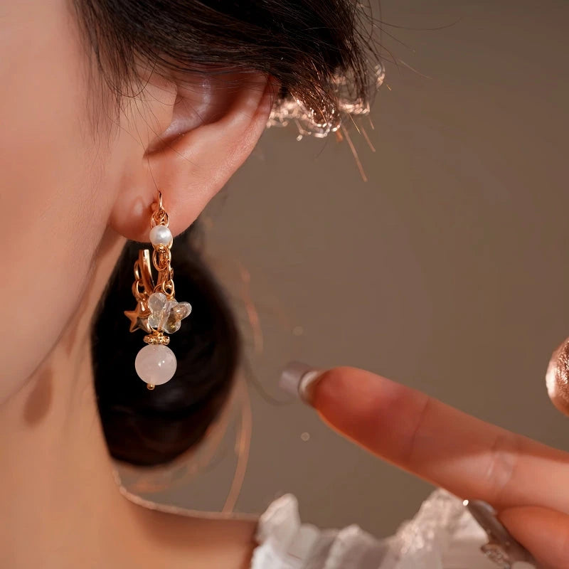 Model showcasing the dangle and style of the 14K Gold-Plated Elegant Zircon Bear Bead Star Tassel Earrings