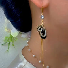 Model showcasing the dangle and style of the 14K Gold-Plated Elegant Zircon Black Butterfly Tassel Ear Hook Earrings