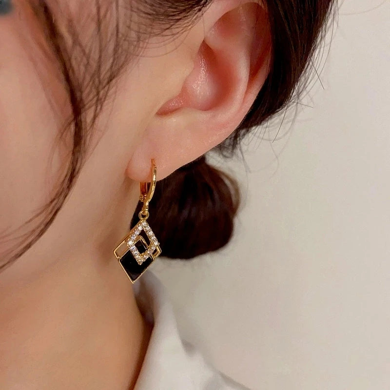 Model showcasing the dangle and style of the 14K Gold-Plated Elegant Zircon Black Double Diamond Earrings