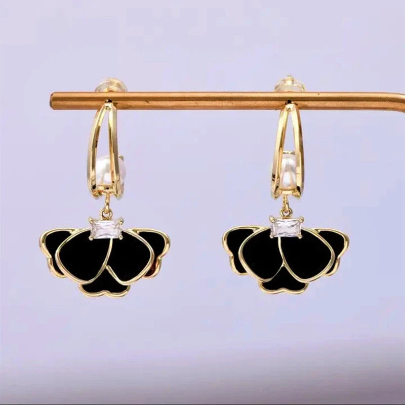 Model showcasing the dangle and style of the 14K Gold-Plated Elegant Zircon Black Petal Earrings