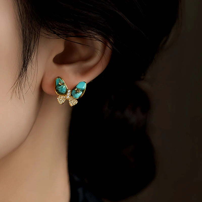 Close-up detail of the sparkling zircons and plating on the green butterfly earrings