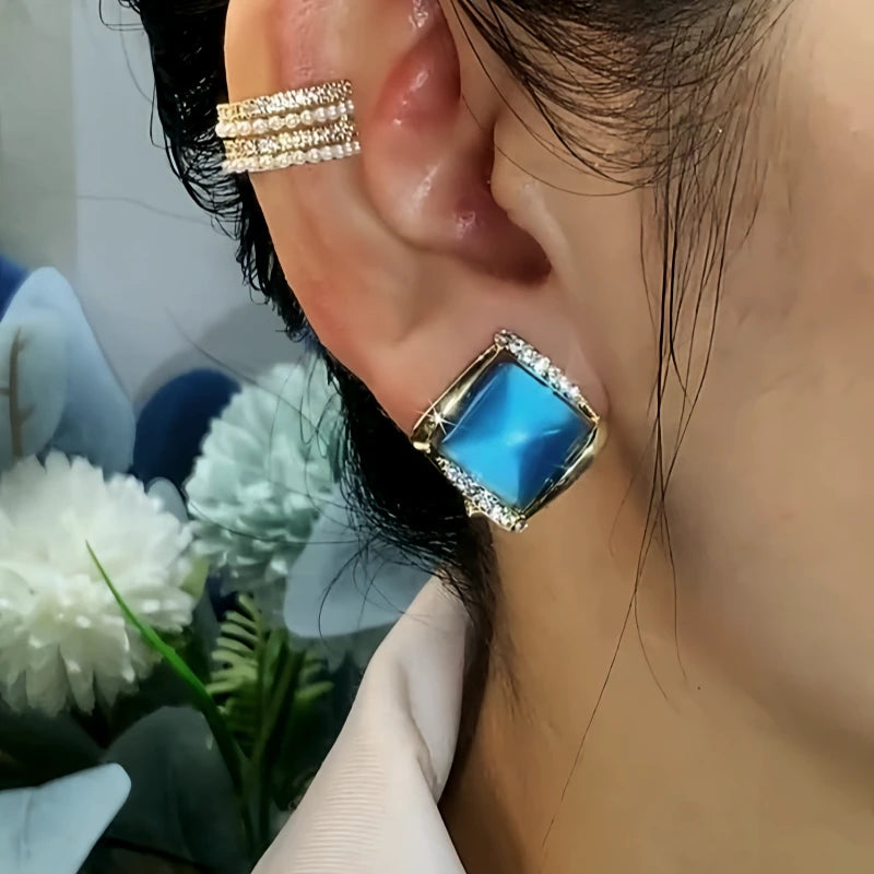 Model showcasing the dangle and style of the 14K Gold-Plated Elegant Zircon Blue Cat's Eye Stone Stud Earrings