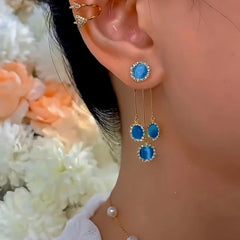 Model showcasing the dangle and style of the 14K Gold-Plated Elegant Zircon Blue Cat's Eye Stone Tassel Earrings