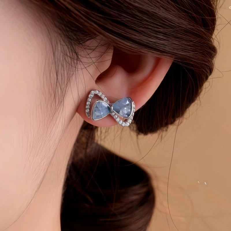 Angled view of the 14K Gold-Plated Elegant Zircon Blue Crystal Bow Stud Earrings