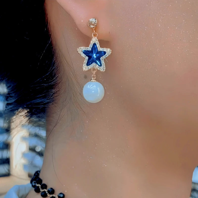 Model showcasing the dangle and style of the 14K Gold-Plated Elegant Zircon Blue Crystal Star Bead Tassel Earrings