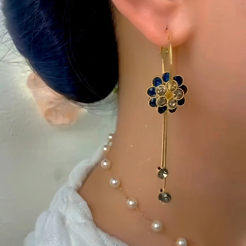 Model showcasing the dangle and style of the 14K Gold-Plated Elegant Zircon Blue Diamond Flower Tassel Earrings