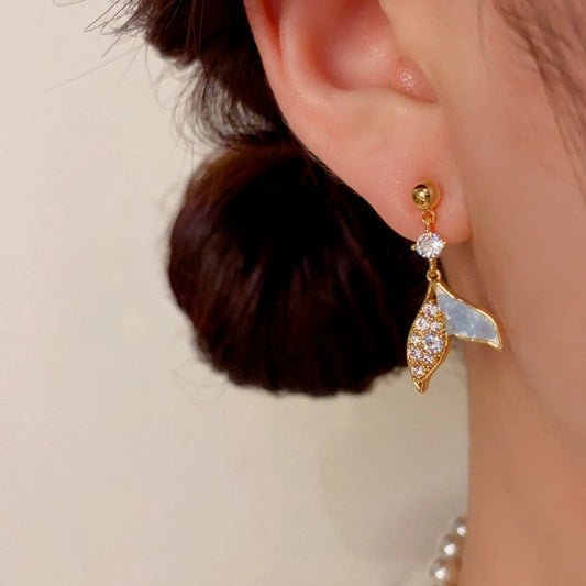 Model showcasing the dangle and style of the 14K Gold-Plated Elegant Zircon Blue Fishtail Tassel Earrings
