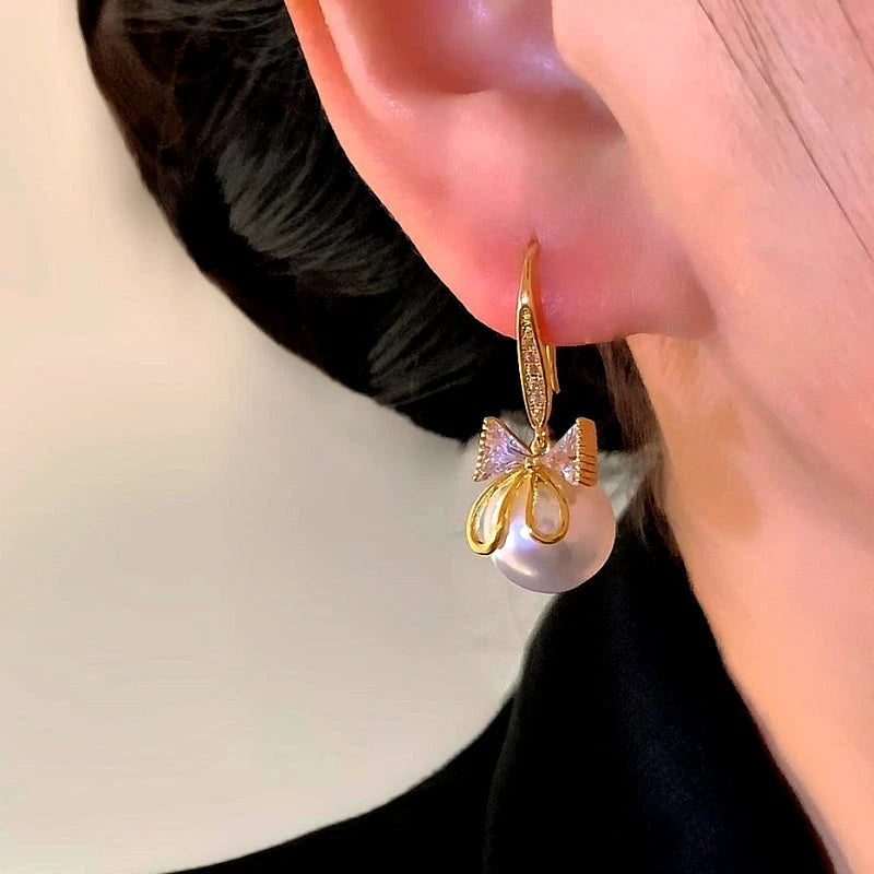 Angled view of the 14K Gold-Plated Elegant Zircon Bow Bead Ear Hook Earrings