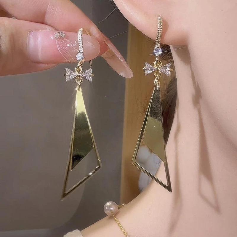 Model showcasing the dangle and style of the 14K Gold-Plated Elegant Zircon Bow Ear Hook Earrings
