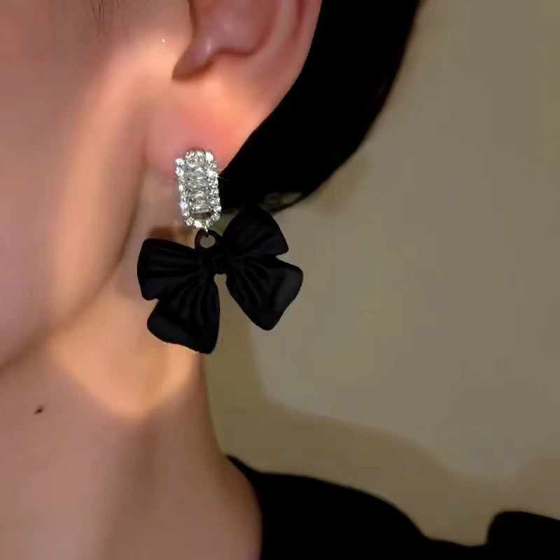 Model showcasing the dangle and style of the 14K Gold-Plated Elegant Zircon Bow Earrings