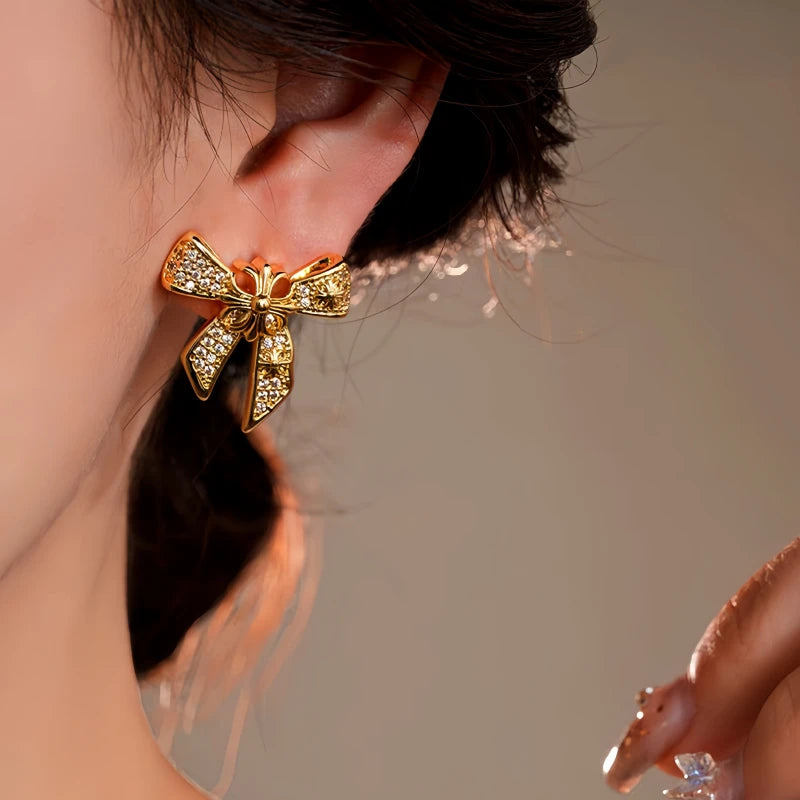Model showcasing the dangle and style of the 14K Gold-Plated Elegant Zircon Bow Earrings