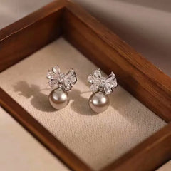 Model showcasing the dangle and style of the 14K Gold-Plated Elegant Zircon Bow Pearl Earrings